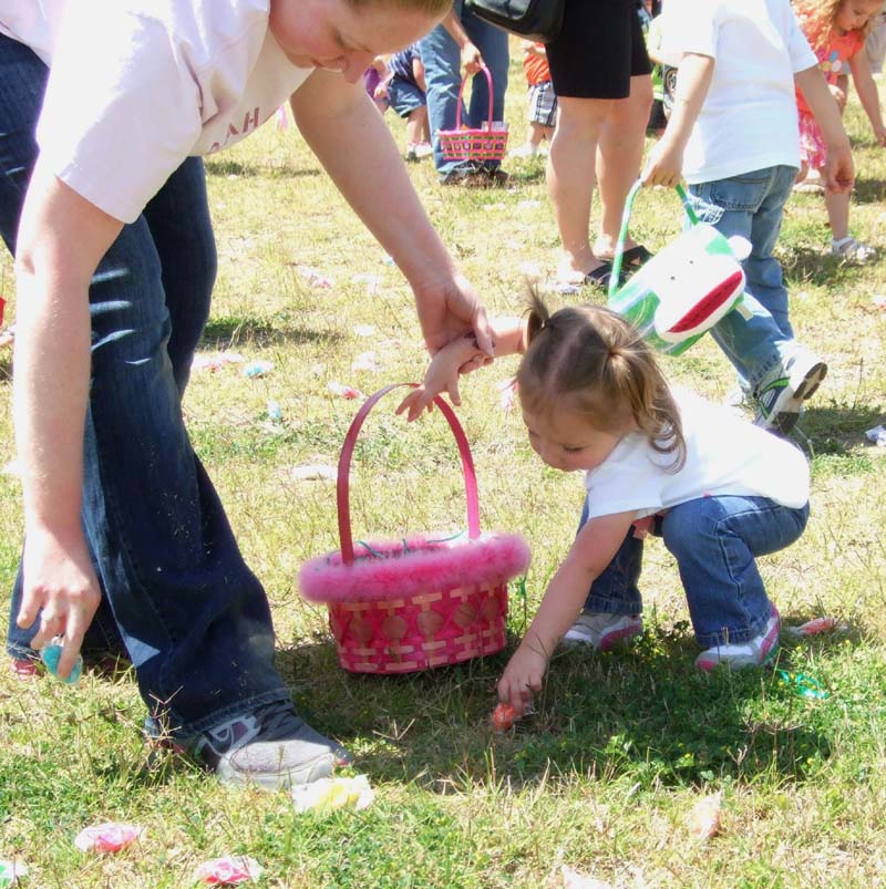 photo of kid and parent hunting for eggs